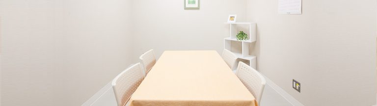 介護施設の居室。ベッドと壁面の収納棚、シンプルで清潔な内装。